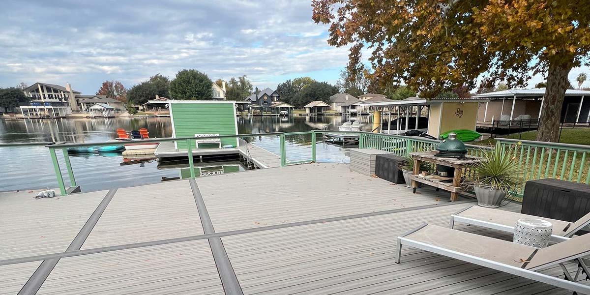 Completed waterside deck with new decking and a glass railing